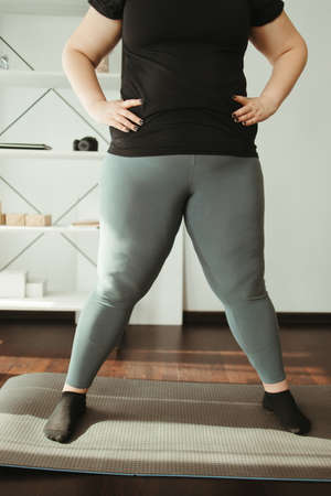 Overweight woman exercising in her living roomの写真素材
