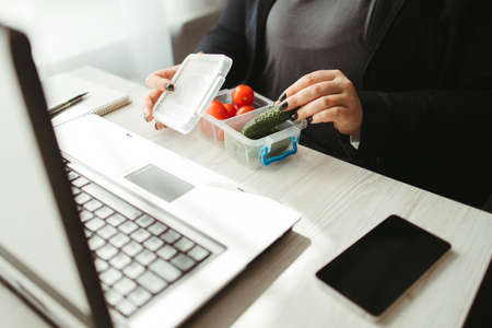 Fat woman eating healthy food at lunch breakの写真素材