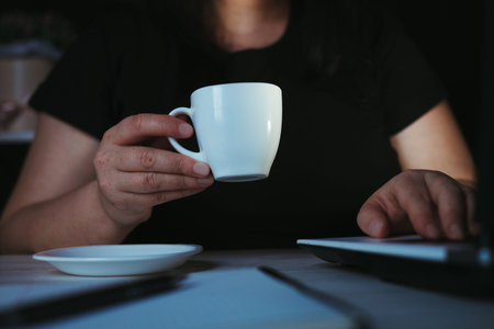 Night work. Woman drinking coffee working late
