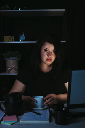 Young focused woman doing overtime job at night
