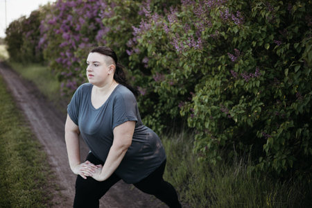 Overweight woman warming up muscles before workout