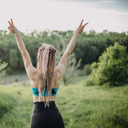Sporty fit woman raising arms express positivity