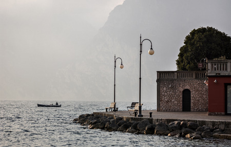 A man fishing near shore of the lake Garda in the northern Italy.の写真素材