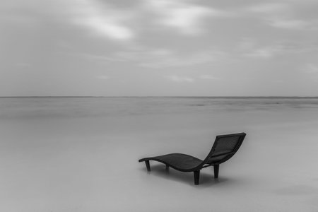 Black and white landscape of lonely sunbed on the beachの写真素材