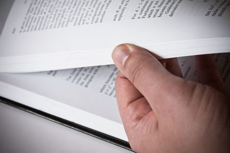 Male hand turning pages of a book with some scientific researchの写真素材