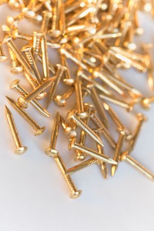 Closeup shot of a heap of small golden nailsの写真素材