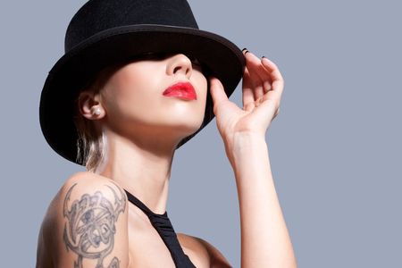 Sexy girl wearing a black hat, isolated on greyの写真素材