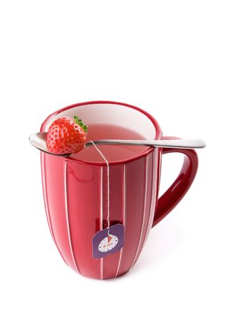 Big cup of fruit tea with strawberries as teabags, isolated on whiteの写真素材