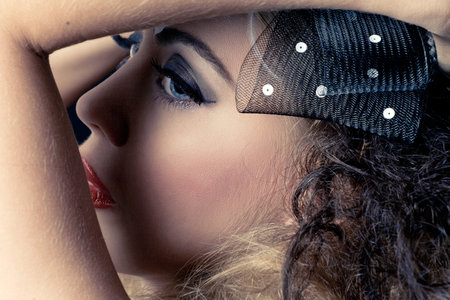 Young beautiful woman with dark eye makeup, closeup studio portrait