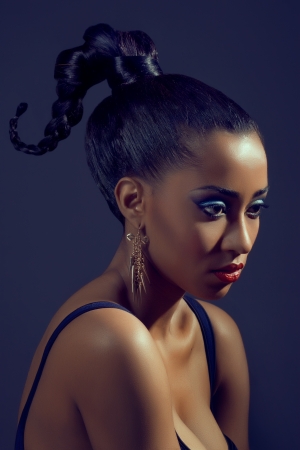Portrait of beautiful woman with stylish creative hairstyle, on dark backgroundの写真素材