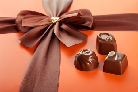Chocolate sweets and beautiful gift box with ribbon bow, closeup shotの写真素材