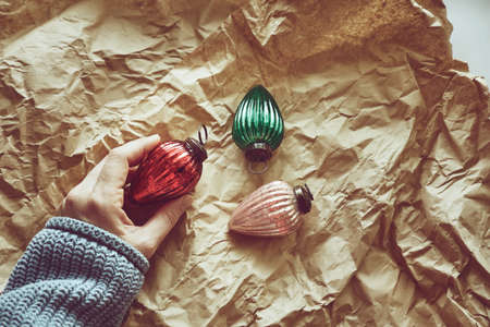 Closeup of womans hand unpacking Christmas tree decorations - colorful drop shaped baubles.の写真素材