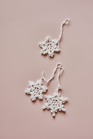 Sustainable and eco-friendly Christmas deco, handmade crochet cotton snowflakes, flatlay on beige