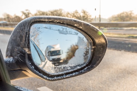Back view through frozen car wing mirror on motorway.の写真素材