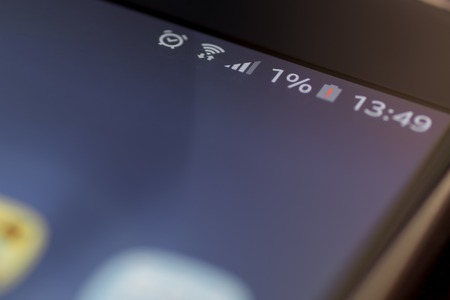 Smartphone with one percent battery charge on the screenの写真素材