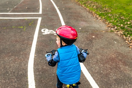 Overhead view of a boy riding bike with safety helmet outdoors at autumn parkの写真素材