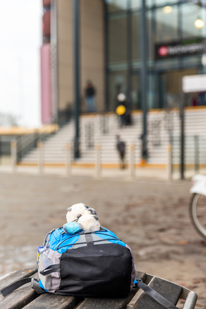 Travel concept of child backpack on bench of train stationの写真素材