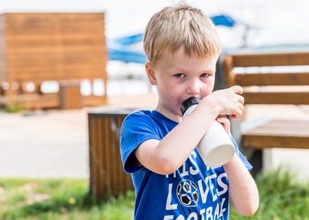 Day light portrait of boy drinking water outdoorの写真素材