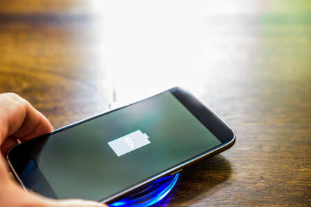Smartphone charging on a charging pad. Wireless charging.の写真素材