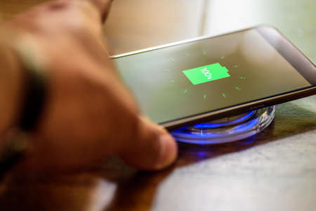 Smartphone charging on a charging pad. Wireless charging.の写真素材