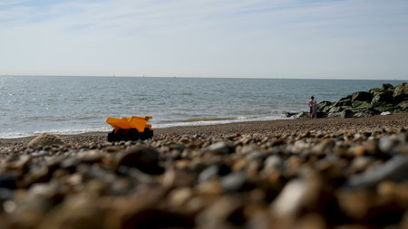 Teen Boy floats at British Seaside on Inflatable Mattress.