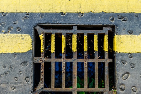 Closeup view of yellow road marking on sewer grateの写真素材