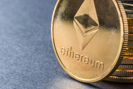 Golden virtual money Ethereum crypto currency coins stacked on a dark background