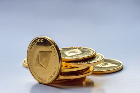 Golden virtual money Ethereum crypto currency coins stacked on a dark background