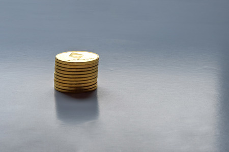 Golden virtual money Ethereum crypto currency coins stacked on a dark backgroundの写真素材