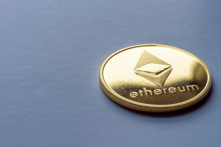 Golden virtual money Ethereum crypto currency coin on a dark backgroundの写真素材