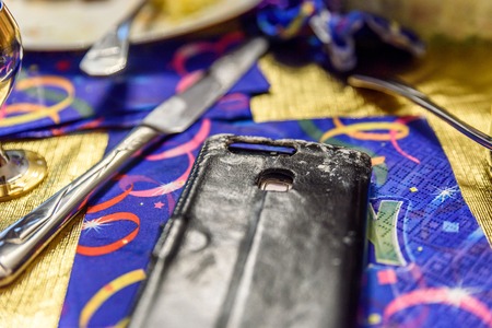 Closeup smartphone with paint drops on it colorful party tableの写真素材