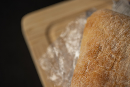 Fresh tasty panini sandwich with plastic waste and paper cardboard inside on wooden board. Recycled waste in our food conceptの写真素材