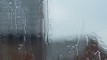 Large rain drops strike open window pane during heavy shower in Englandの写真素材
