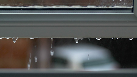 Large rain drops strike open window pane during heavy shower in Englandの写真素材