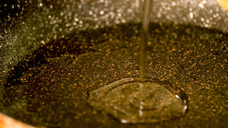 Closeup view pouring vegetable oil into pre heat frying panの写真素材