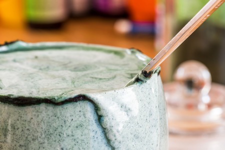 Closeup view fresh kefir probiotik drink in clear glass mixed with green spirulina powder on kitchen tableの写真素材