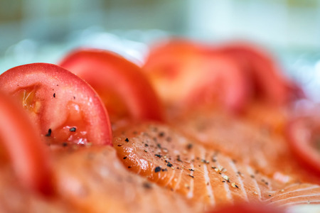 Closeup view fresh raw salmon fillets with herbs and spices on baking tray ready to be cooked in oven.の写真素材