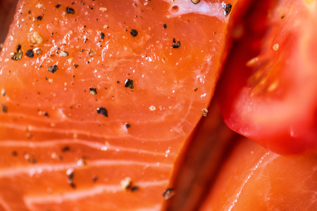 Closeup view fresh raw salmon fillets with herbs and spices on baking tray ready to be cooked in oven.の写真素材