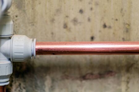 new copper pipe over mouldy concrete wall in england ukの写真素材