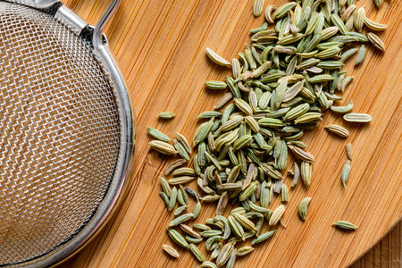fennel seeds loose with sieve on wooden board ready to be brewed as teaの写真素材