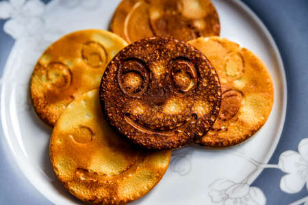smile face pancakes on plate in kitchenの写真素材