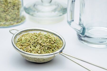 fennel seeds loose inside sieve ready to be brewed for healthy drink on white backgroundの写真素材