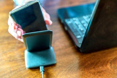 man charging smartphone using Wireless charging stand at home office