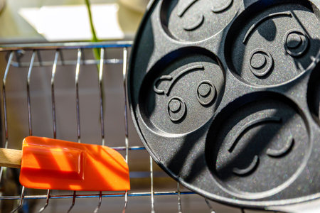 black pancake smile frying pan on plate drainer rack in kitchen