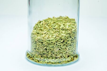 fennel seeds loose inside glass jar on white background.の写真素材