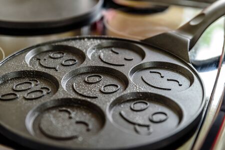 pancake frying pan with smile face pancake cooking on cooker in kitchenの写真素材