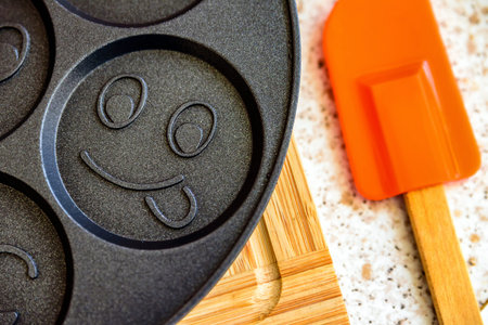 black pancake smile frying pan on worktop in kitchen