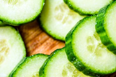 Cucumber cut slices on wooden cutting boardの写真素材