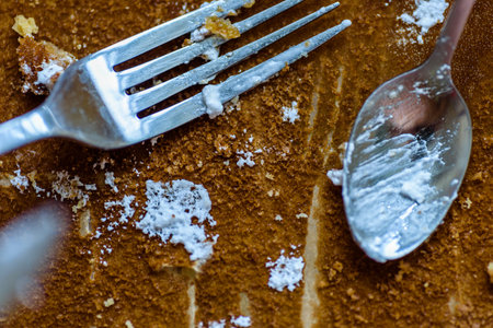 fork knife and spoon covered with apple pie icing on empty baking paper tray.