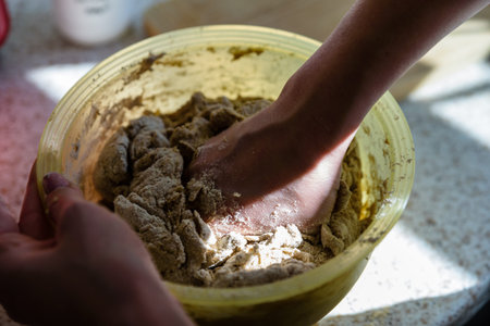 mixing wholemeal homemade vegan bread in plastic bowl.